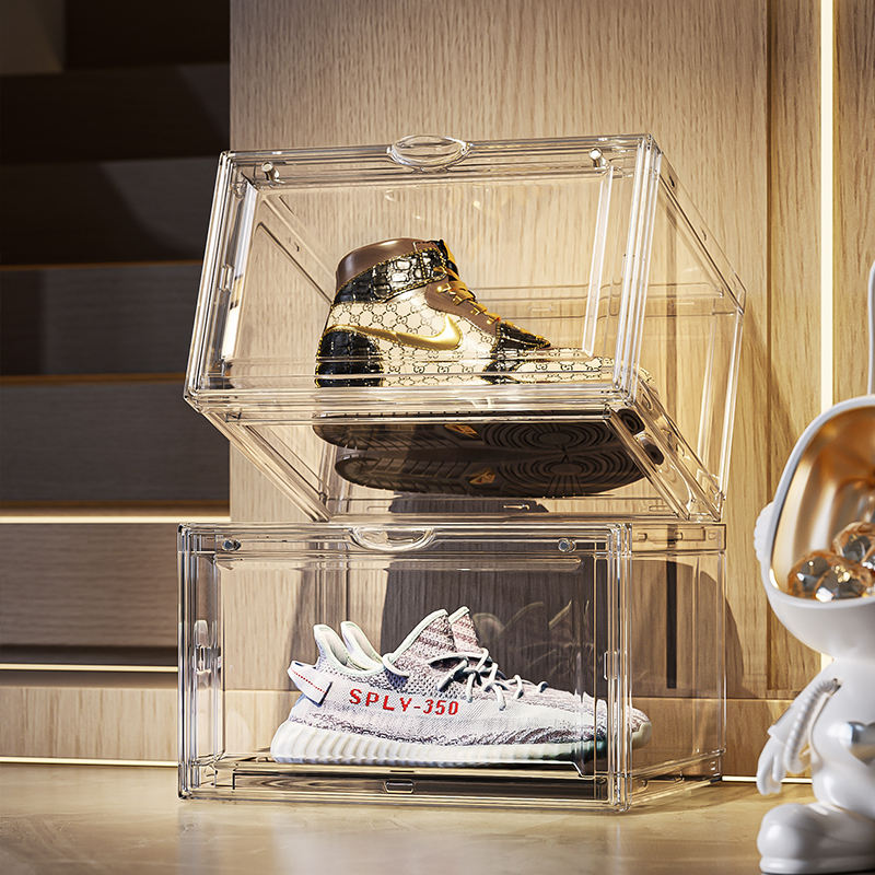 Clear plastic shoe storage box stacked two levels with sneakers and boots inside