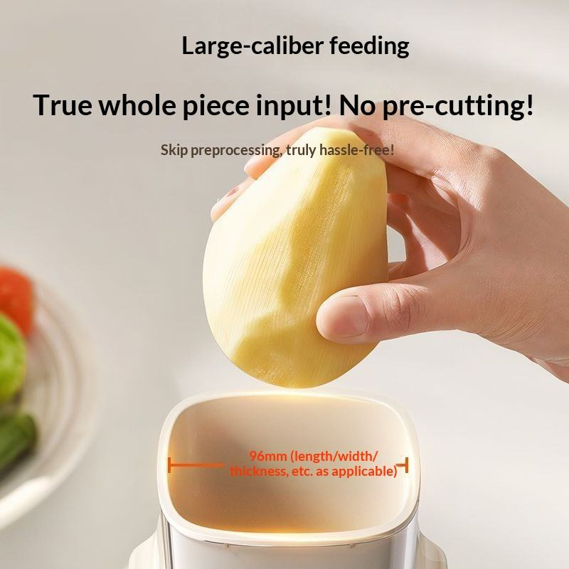 Automatic vegetable slicer with large feed opening as a hand inserts a whole vegetable.